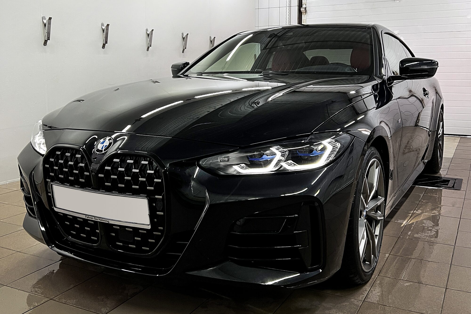 Чёрный BMW в светлом боксе The Details после мойки