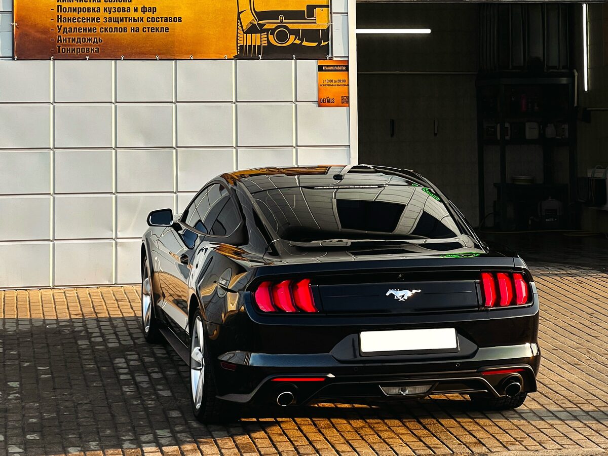 Чёрный Ford Mustang у въезда в бокс детейлинга The Details